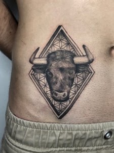 Tatuaje toro geométrico black grey costado — CAOS Art Tattoo Chile