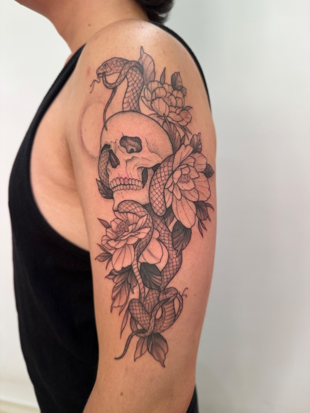 Tatuaje calavera serpiente flores dotwork — CAOS Art Tattoo Chile