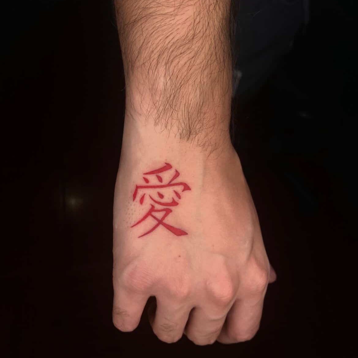 Tatuaje Kanji amor rojo en mano — CAOS Art Tattoo Chile