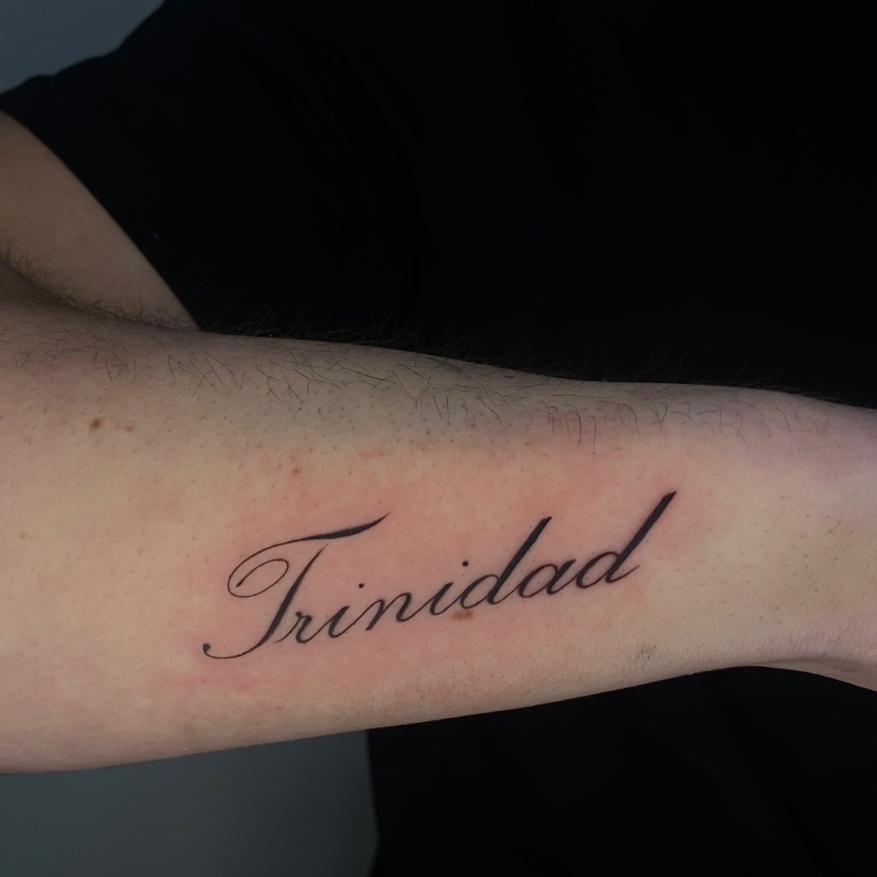 Tatuaje Trinidad nombre caligrafía fina — CAOS Art Tattoo Chile