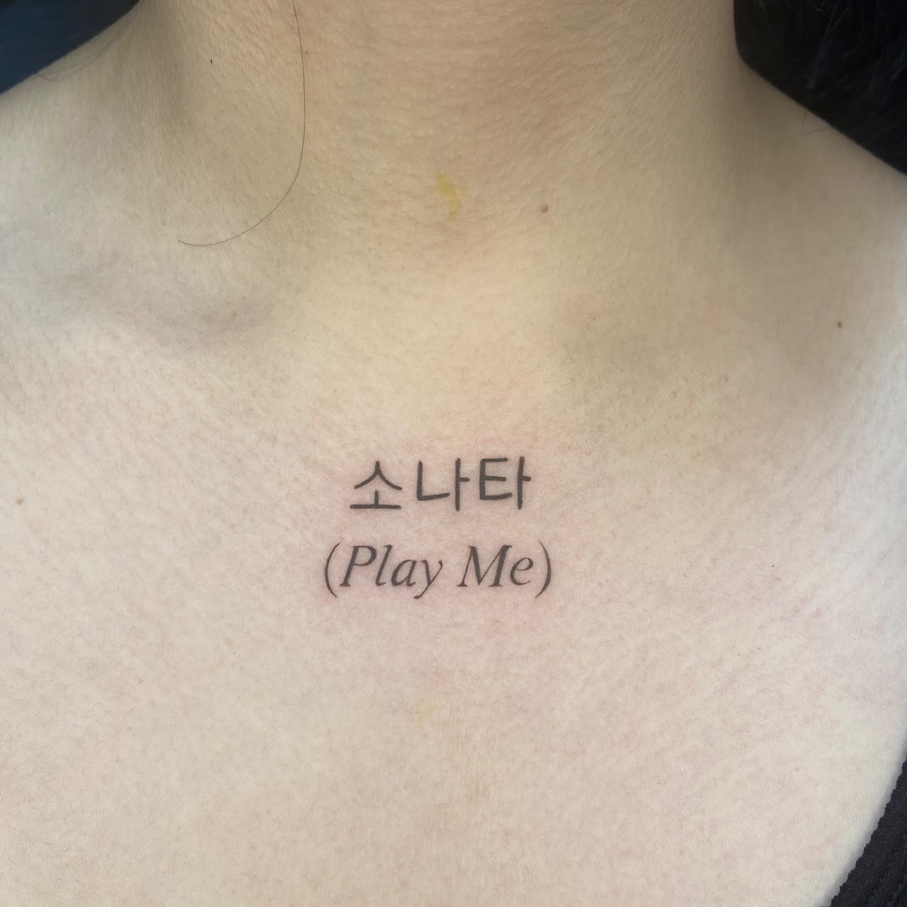 Tatuaje Hangul coreano Play Me en pecho — CAOS Art Tattoo Chile