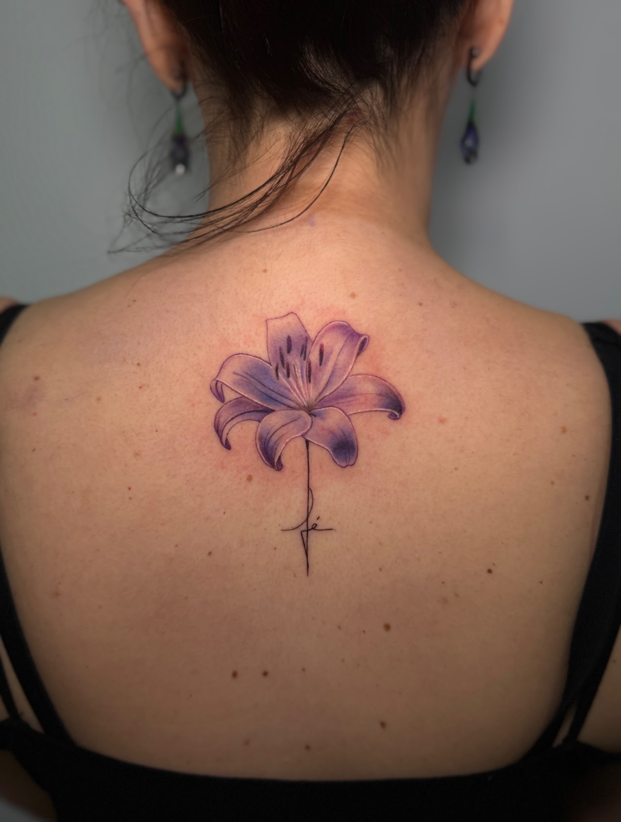 Tatuaje Lirio lila acuarela espalda con lettering fe — CAOS Art Tattoo Chile