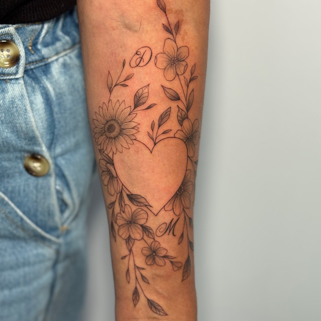 Tatuaje Corazón floral con girasol e iniciales fineline — CAOS Art Tattoo Chile