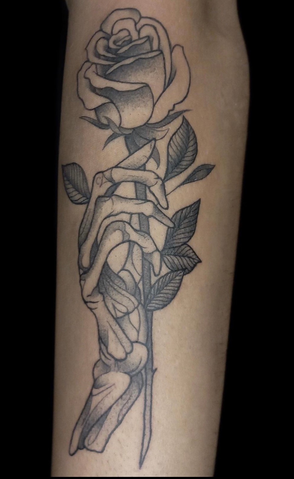 Tatuaje Rosa con mano esqueleto blackwork — CAOS Art Tattoo Chile