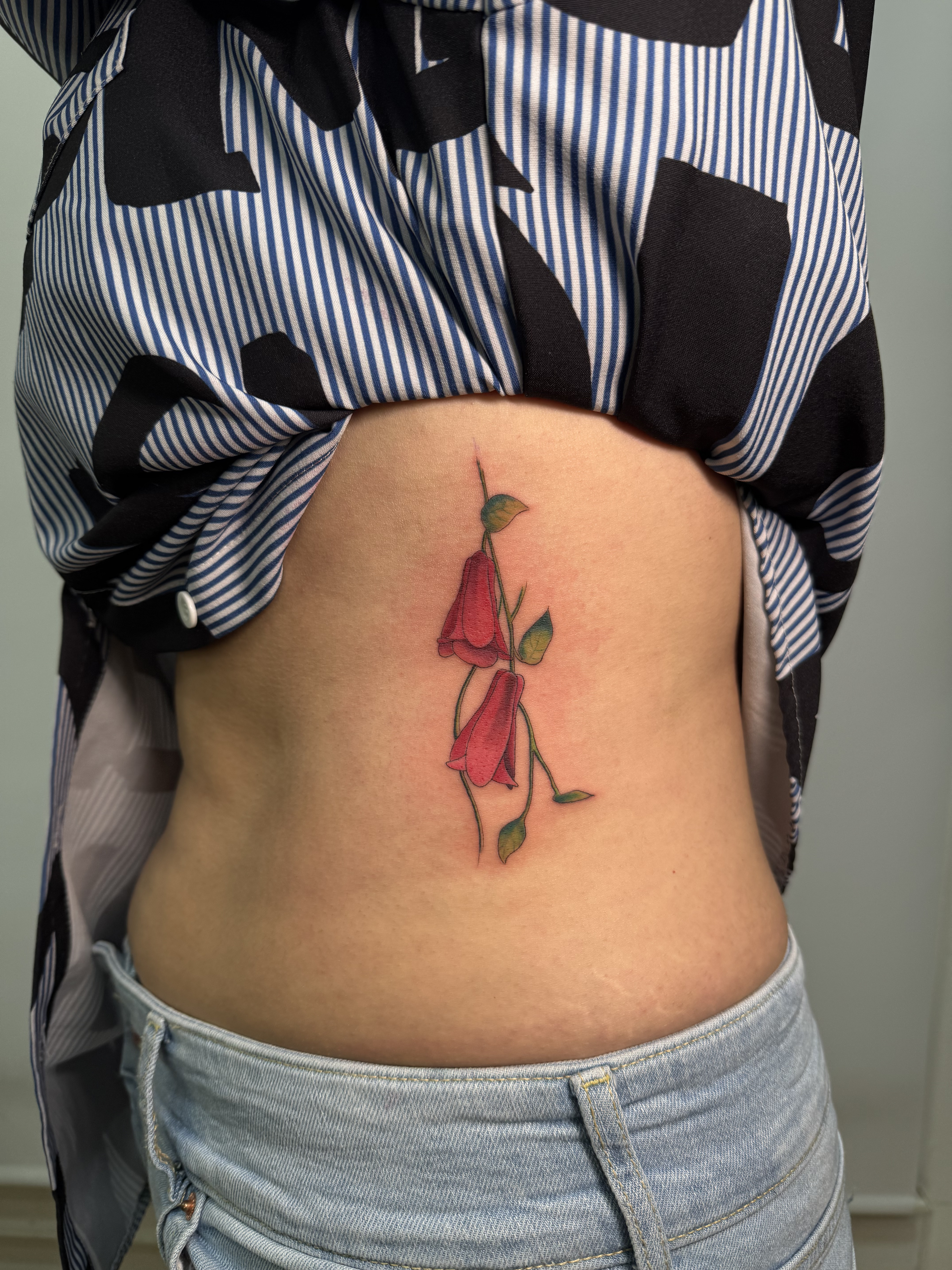Tatuaje Copihue flores rojas color costillas — CAOS Art Tattoo Chile