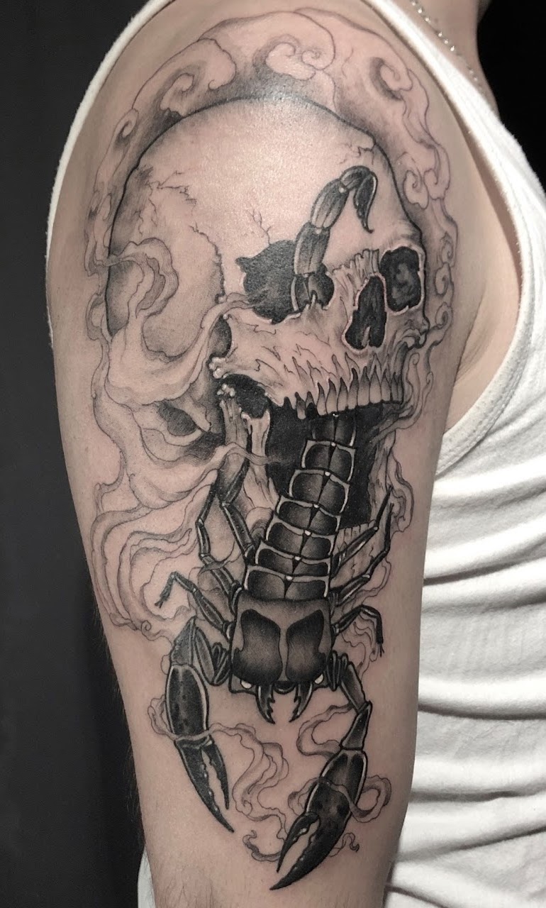 Tatuaje Escorpión con cráneo blackwork en brazo — CAOS Art Tattoo Chile