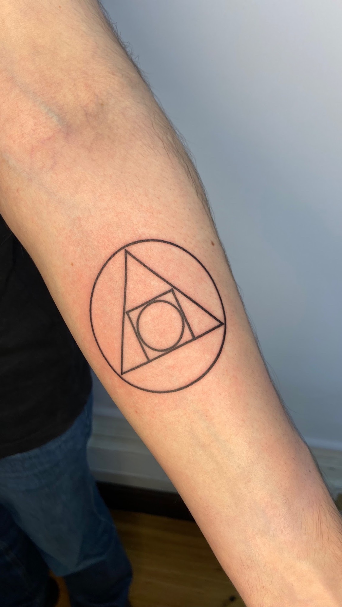 Tatuaje Símbolo geométrico triángulo círculo lineal — CAOS Art Tattoo Chile