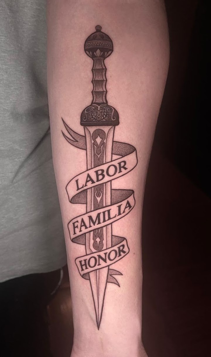 Tatuaje Espada con cinta Labor Familia Honor blackwork — CAOS Art Tattoo Chile