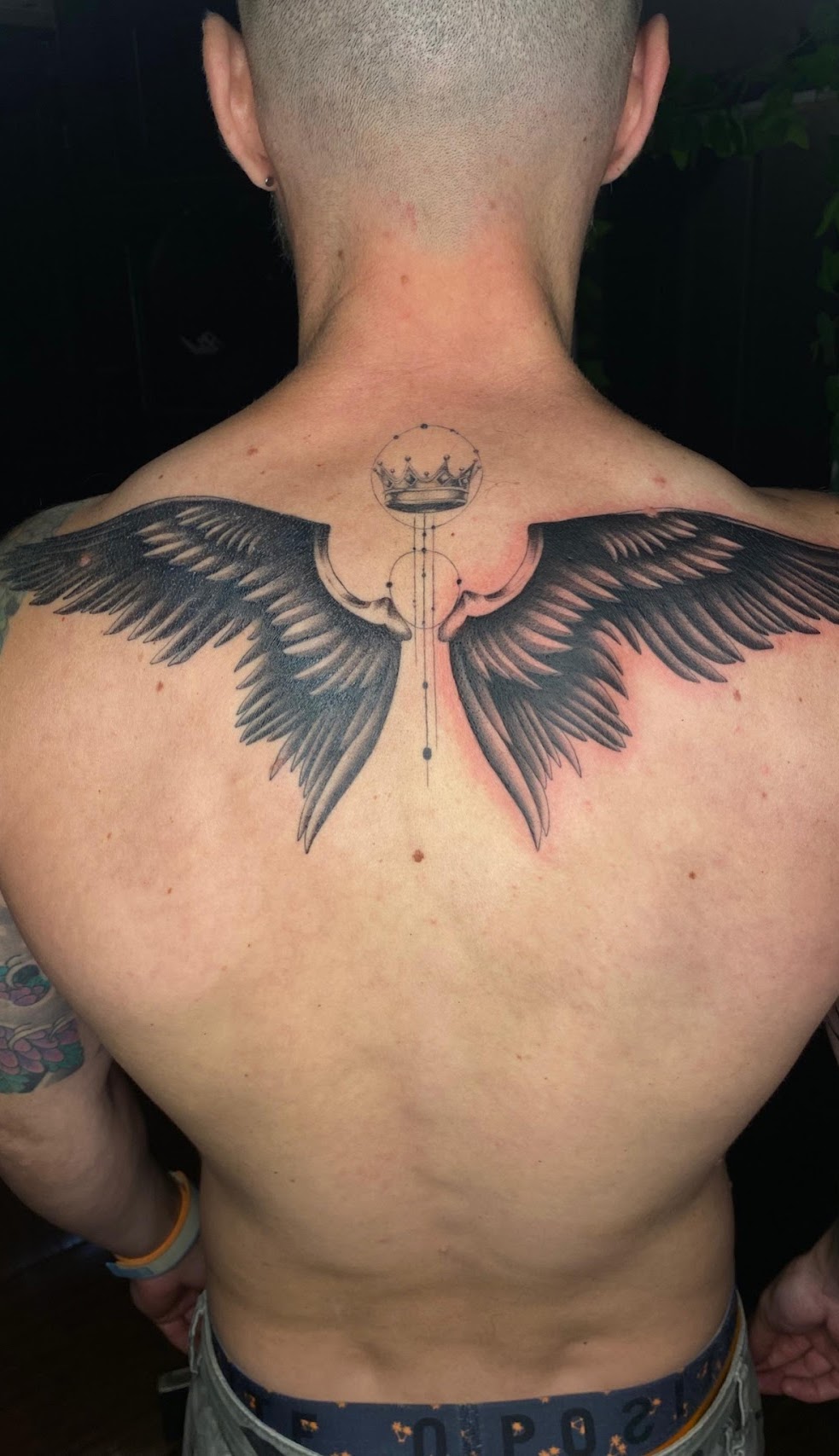 Tatuaje Alas blackwork con corona en espalda — CAOS Art Tattoo Chile