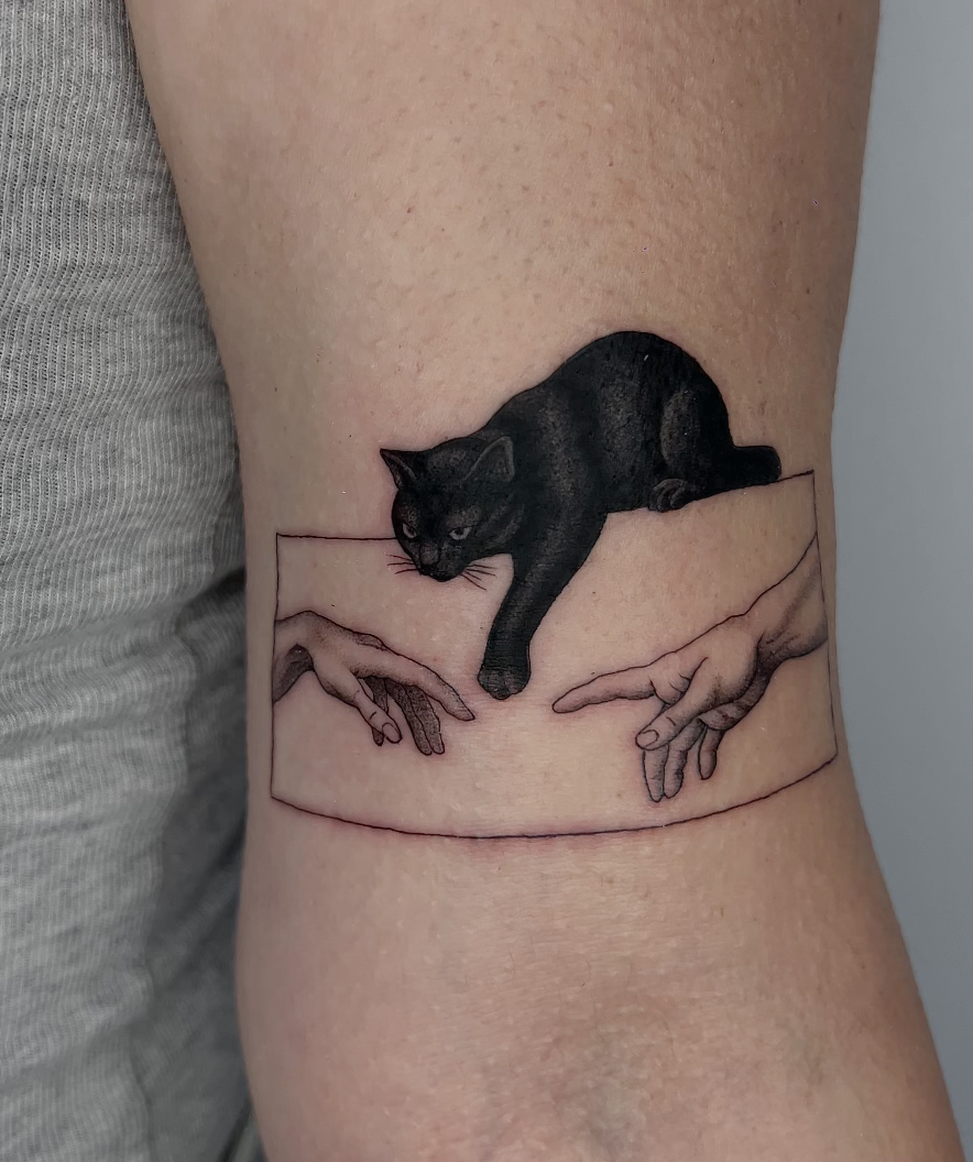 Tatuaje gato negro La Creación de Adán microrealismo — CAOS Art Tattoo Chile