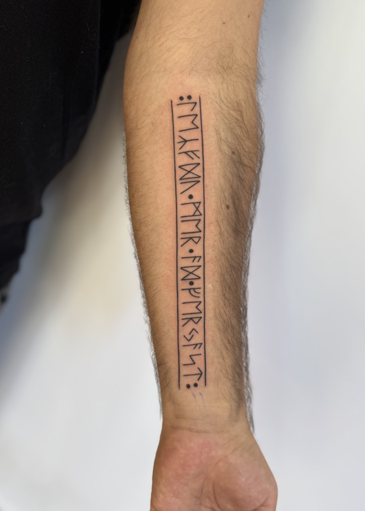 Tatuaje Inscripción rúnica vertical lineal — CAOS Art Tattoo Chile