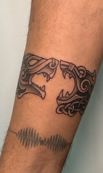 Tatuaje Brazalete lobos celtas enfrentados — CAOS Art Tattoo Chile