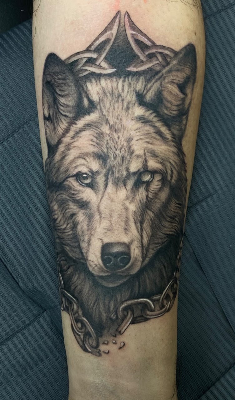 Tatuaje Lobo Fenrir con corona celta y cadena rota — CAOS Art Tattoo Chile