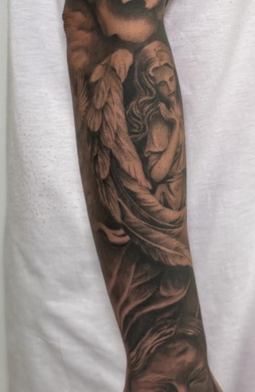 Ángel en antebrazo — tatuaje realismo — CAOS Art Tattoo Chile